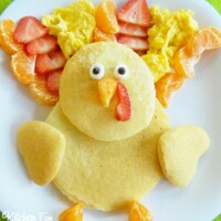 Thanksgiving Turkey Pancakes with fruit and eggs on a plate