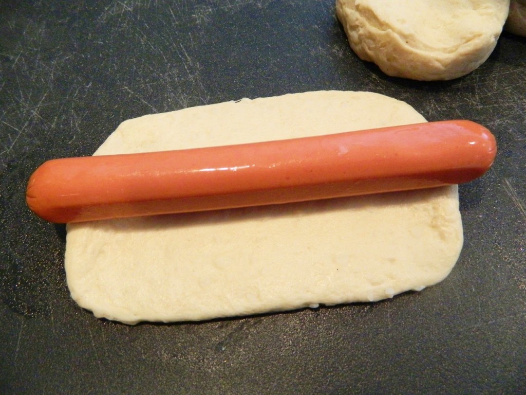 roll out the dough to fit the hot dog leaving the ends poking out a bit
