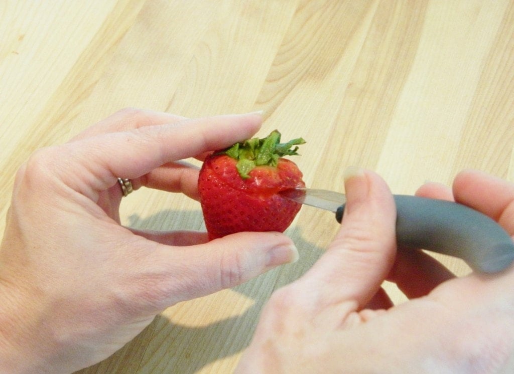 Start out by cutting off the top of a strawberry down the to middle