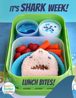 A bunch of sea-themed snacks inside of a bright green lunch box