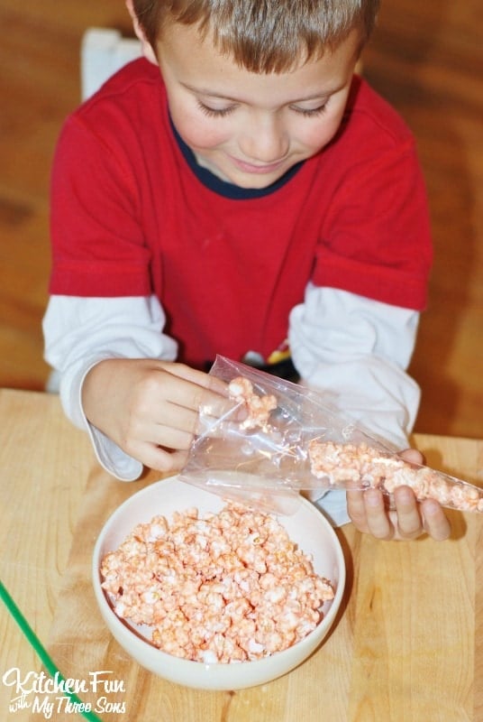 Boy Making Easter Popcorn Carrot treat bags