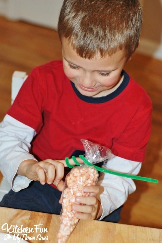 Boy Making Easter Popcorn Carrot treat bags