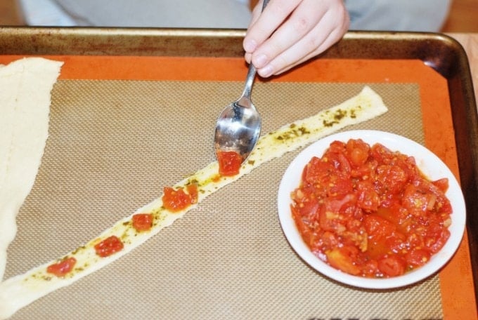 adding tomatoes to the crescent strip