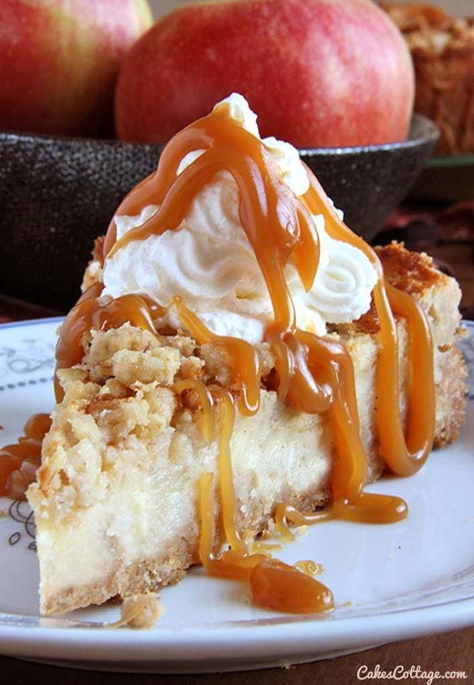 A slice of Caramel Apple Crisp Cheesecake with whipped cream and caramel topping.