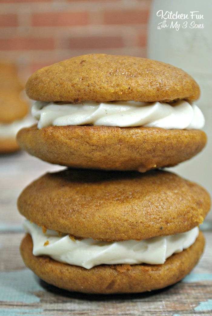 Two Pumpkin Whoopie Pies balanced on top of each other, each filled with piped cream filling.