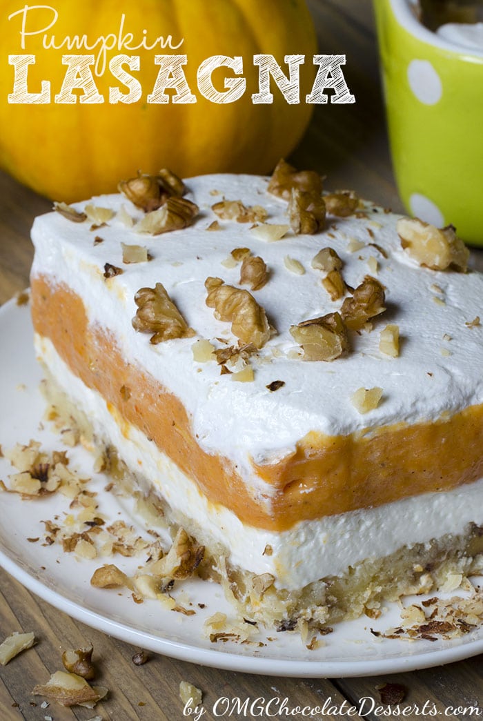 A close-up shot of a square of of layered pumpkin lasagna dessert. Each layer is distinct and the serving is topped with chopped pecans.
