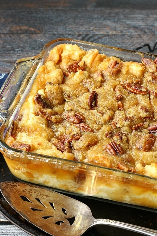 A glass casserole dish filled with pecan pie bread pudding. A pie slice serving utensil sits nearby.