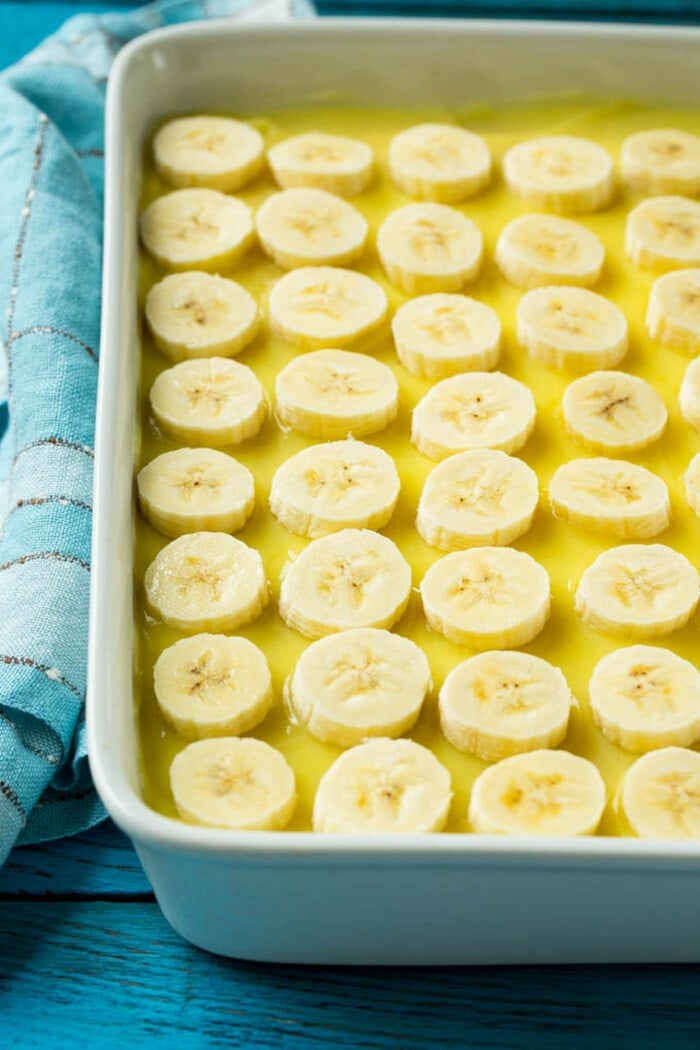 Banana slices on top of pudding in a cake pan