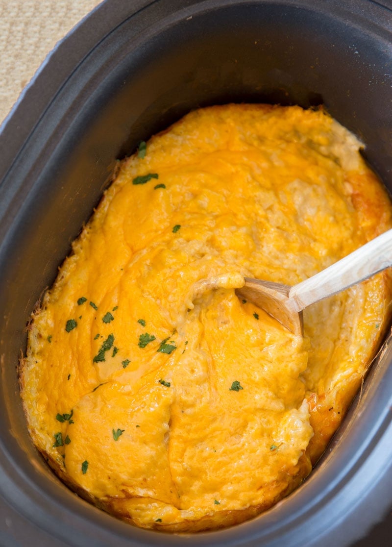 Hash brown casserole in a slow cooker covered with cheese