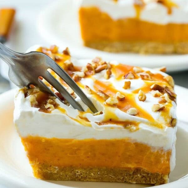 This easy no-bake pumpkin lush is layers of graham cracker crust, pumpkin pudding and whipped topping, all topped with caramel and pecans. The ultimate fall dessert!