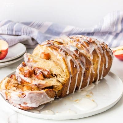 Apple Pull Apart Bread is the perfect recipe to make on an Autumn day after a day of apple picking. Flaky biscuits with fresh apples coated in sugar and spices all topped with a delicious glaze.