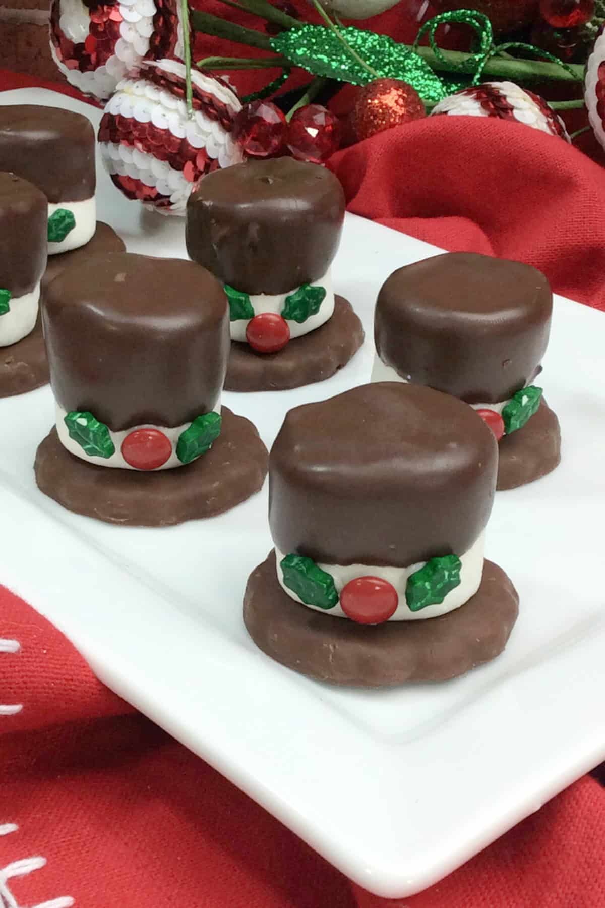These Snowman Hat Cookies are such a fun Christmas treat to make with or for kids using just 5-ingredients including Grasshopper cookies, chocolate and assorted candies! top view of Snowman Hat Cookies on a platter