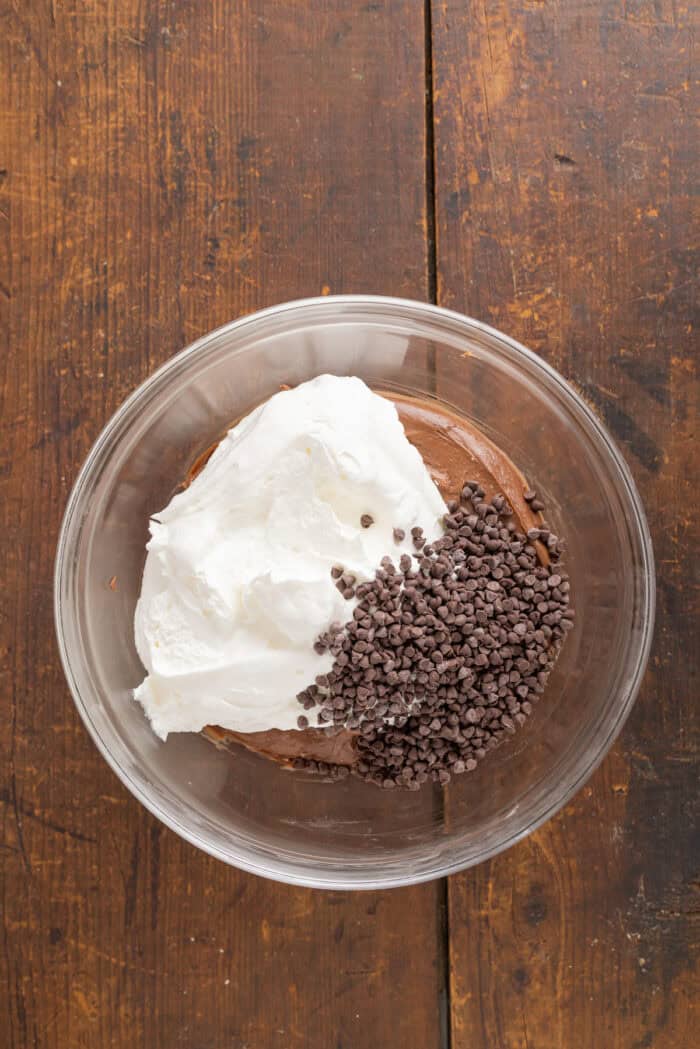 Brownie mix cream cheese, whipped cream, and mini chocolate chips in a bowl