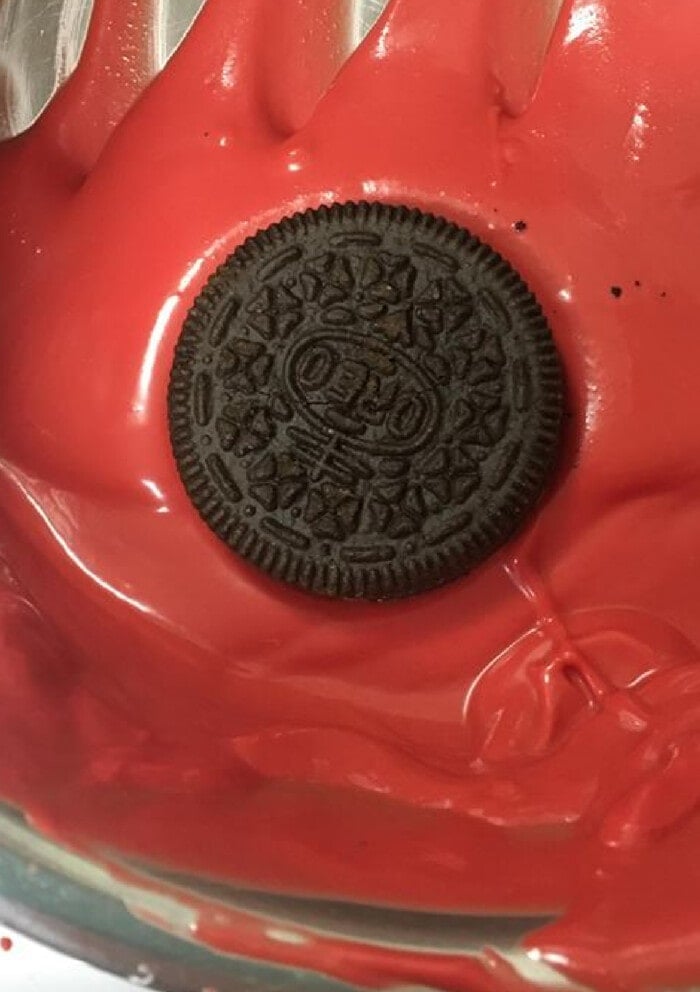 Oreo Cookie being dipped in red chocolate