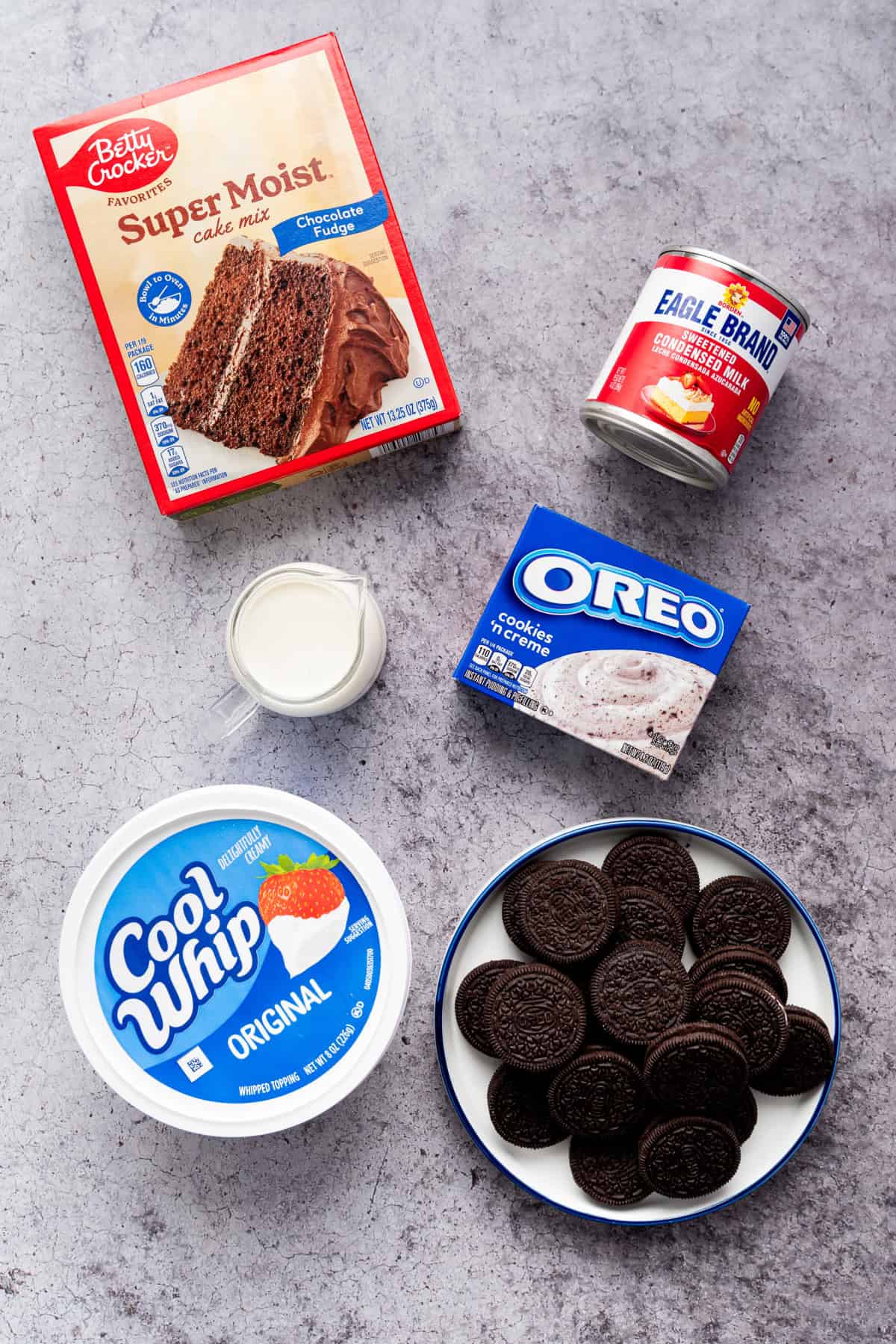 This Oreo Poke Cake is an easy, crowd-pleasing dessert that's loaded with rich chocolate cake, creamy cookies and cream pudding, fluffy whipped topping, and plenty of crushed Oreo cookies. ingredients for Oreo poke cake