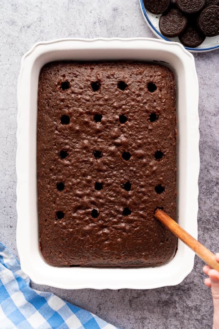 poking holes in a baked chocolate cake