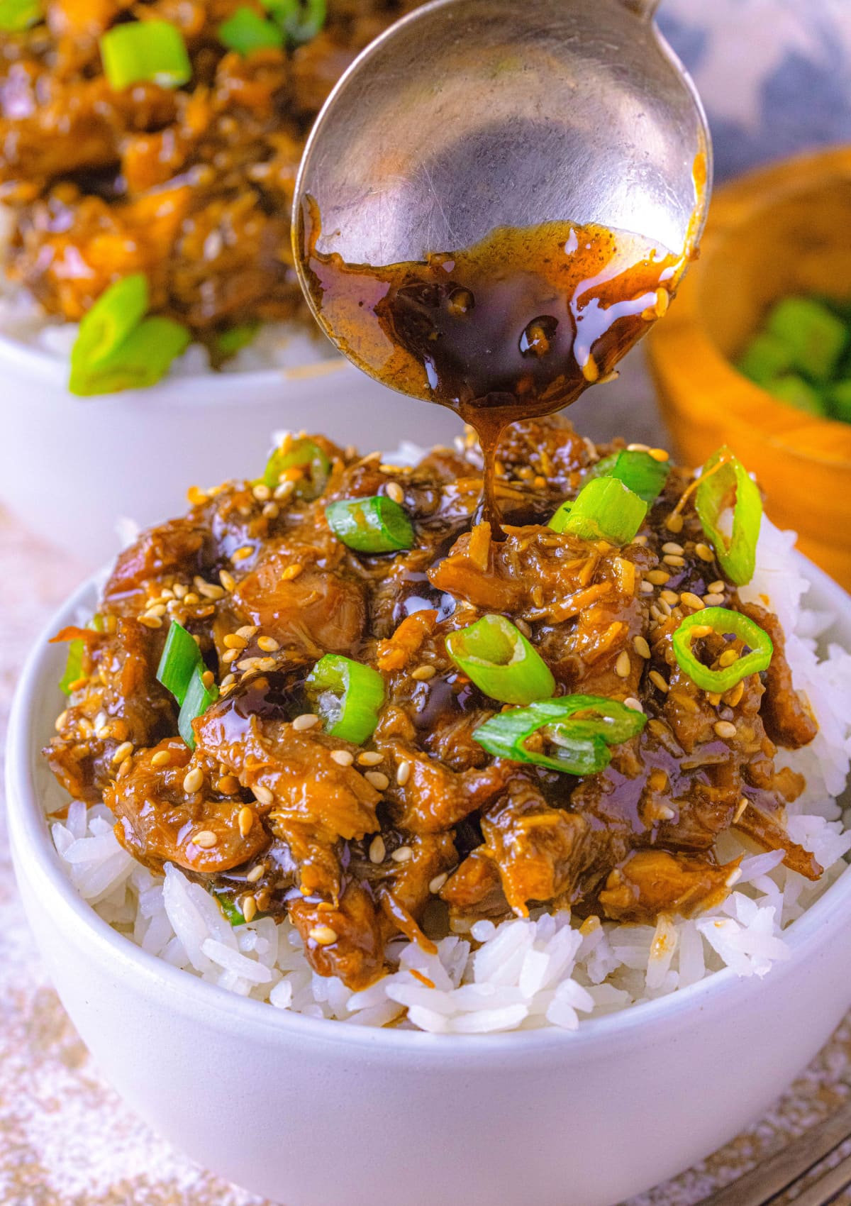 Slow Cooker Teriyaki Chicken with sauce poured on top with a spoon