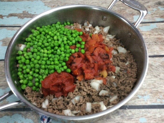 peas, tomatoes and ground beef in a pan