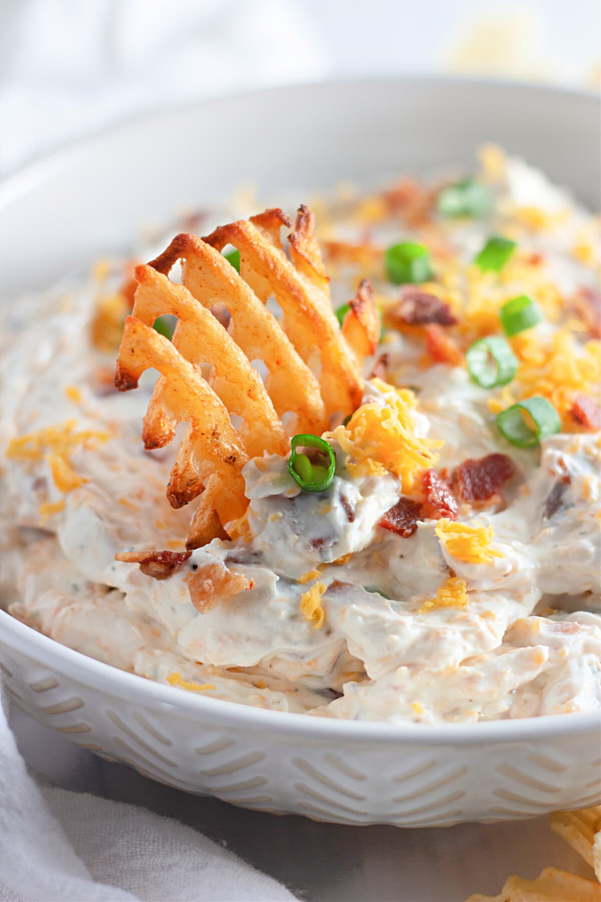 french fry dipped in loaded baked potato dip