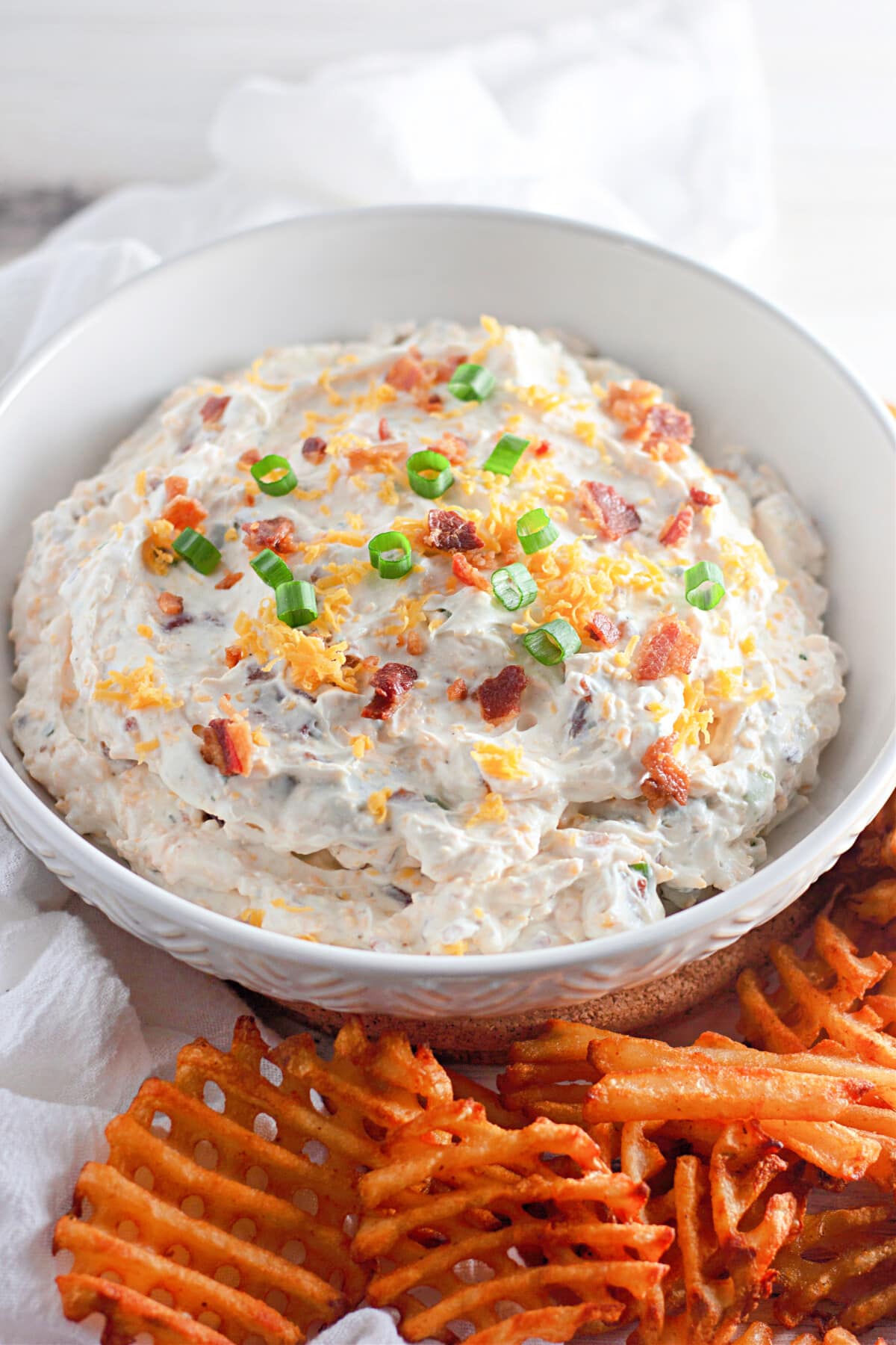 loaded baked potato dip in a bowl with french fries
