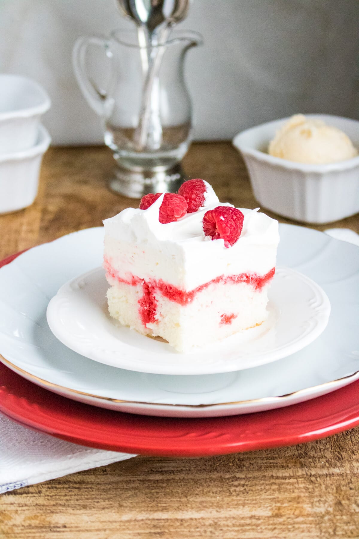 Raspberry Poke Cake on a white plate.
