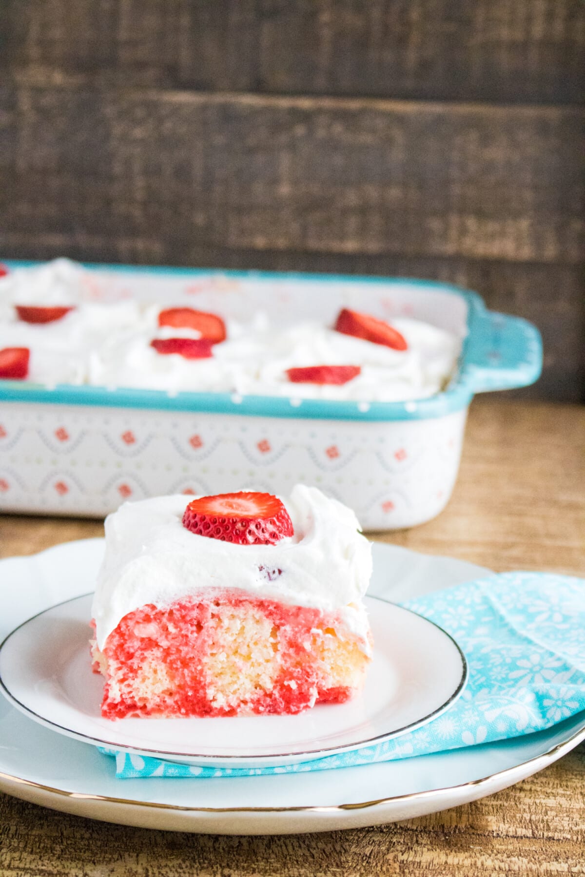 Strawberry Poke Cake on a wooden table.
