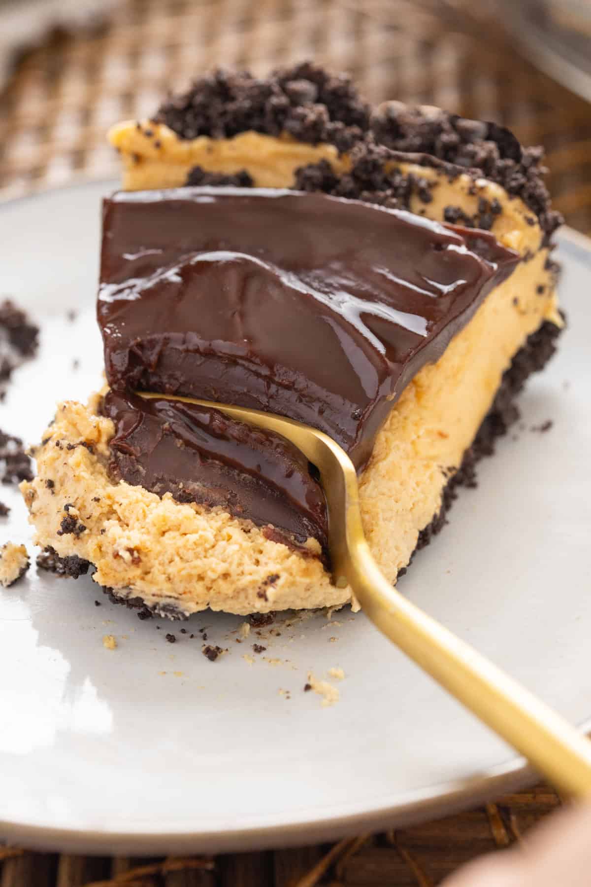 A fork in a slice of chocolate peanut butter pie