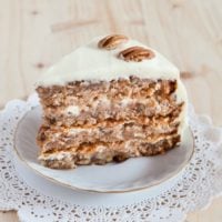 A slice of Hummingbird Cake showing the layers of cake with cream cheese frosting in between.