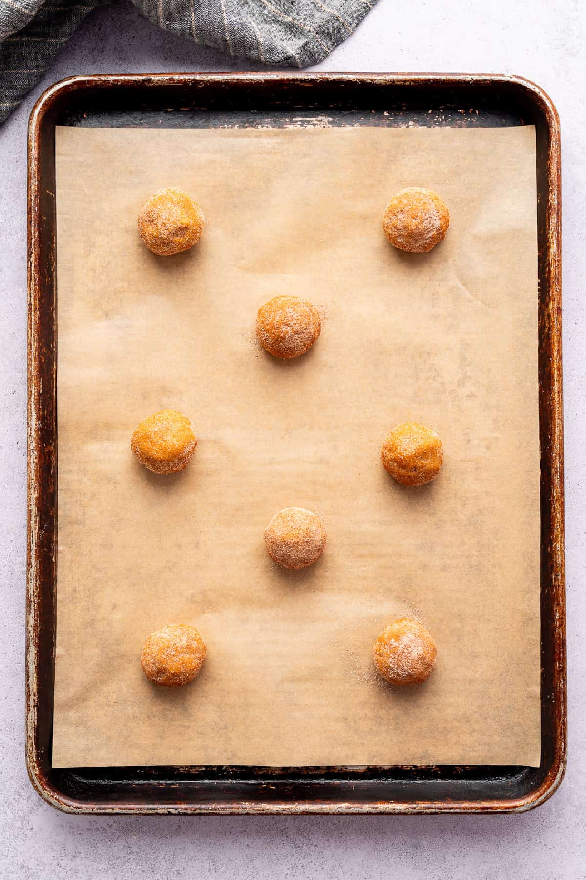 pumpkin snickerdoodle dough formed into balls on a baking sheet