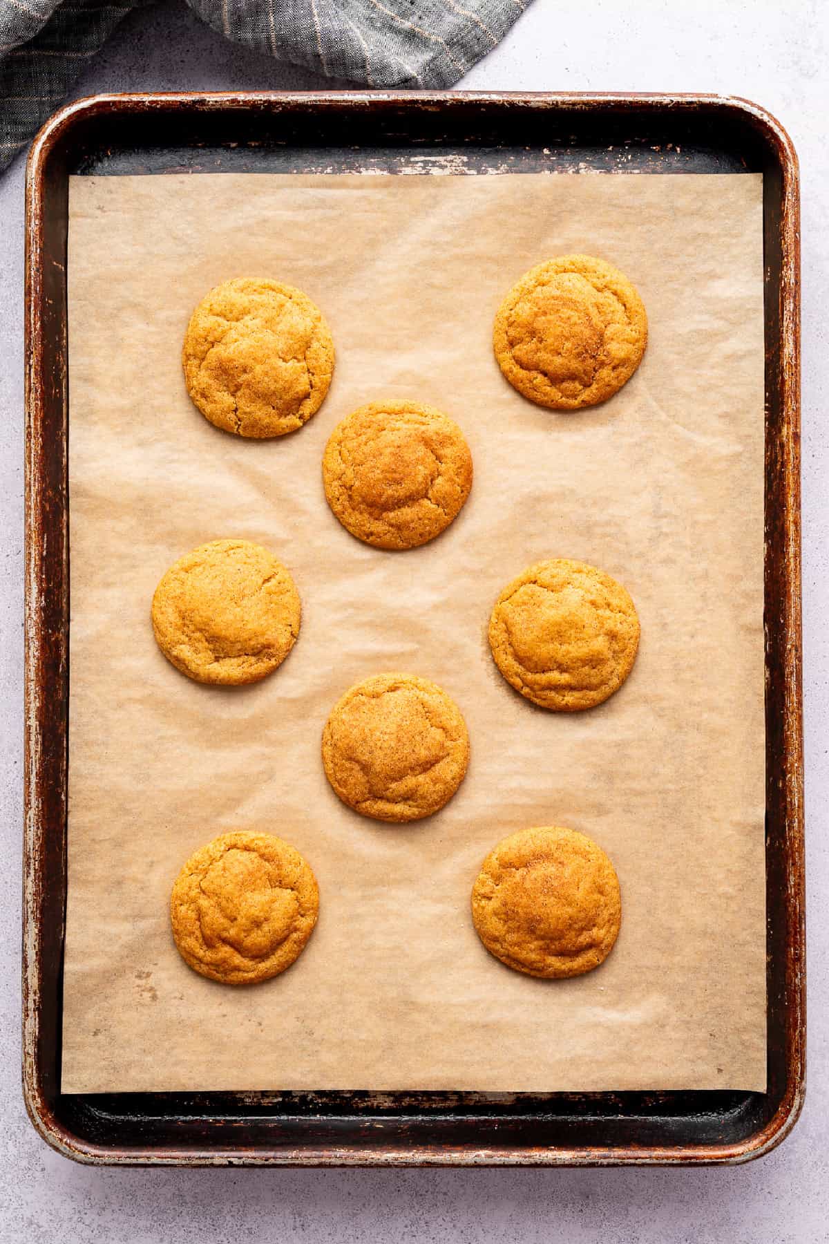 baked pumpkin snickerdoodles on a baking sheet