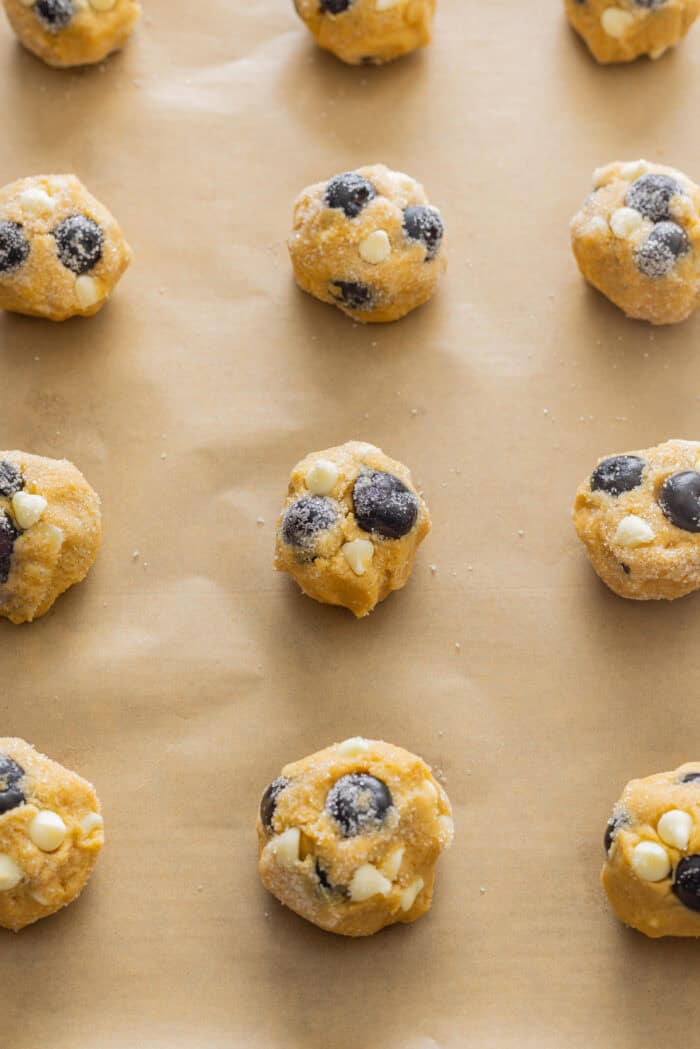 Balls of blueberry cookie dough on a baking sheet