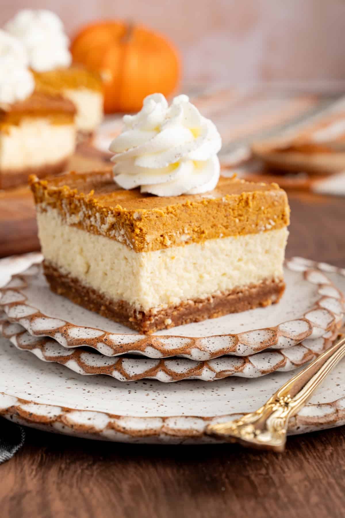 layered pumpkin cheesecake bar on a plate