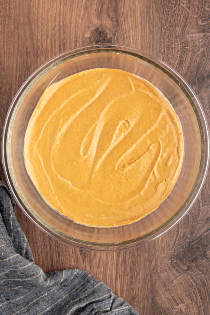 These Pumpkin Cheesecake Bars is the ultimate Fall dessert that starts with a cinnamon graham cracker crust that's layered with creamy vanilla cheesecake and then topped with spiced pumpkin cheesecake. pumpkin cheesecake mixtures in a bowl
