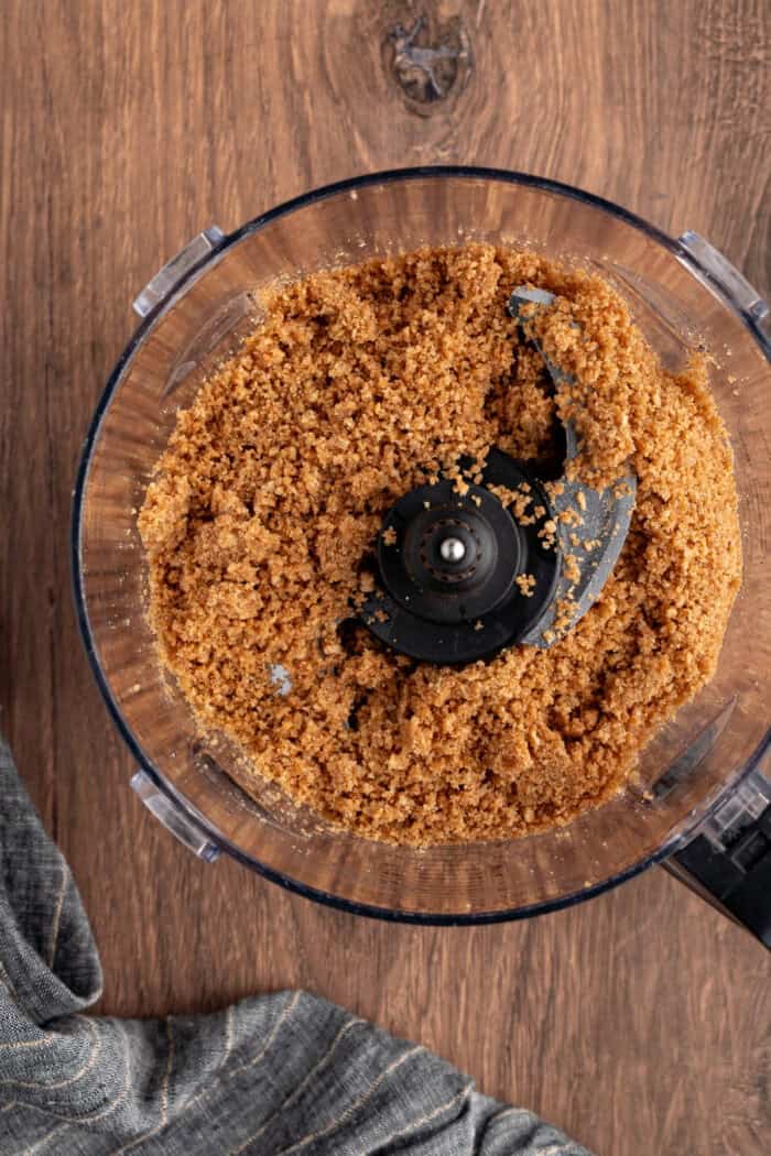 These Pumpkin Cheesecake Bars is the ultimate Fall dessert that starts with a cinnamon graham cracker crust that's layered with creamy vanilla cheesecake and then topped with spiced pumpkin cheesecake. crushed graham cracker crumbs in a food processor