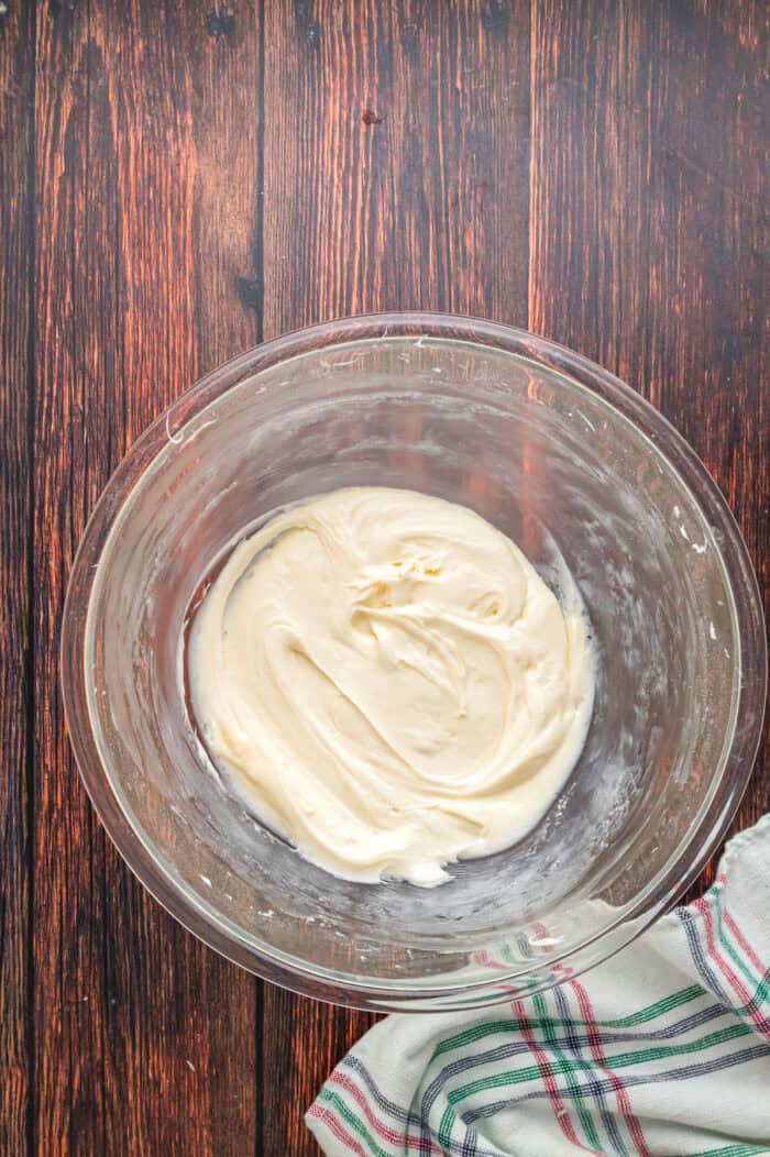 Warmly spiced, moist bread is topped with tangy cream cheese frosting in this Gingerbread Loaf recipe, inspired by Starbucks. Cream cheese frosting in a bowl