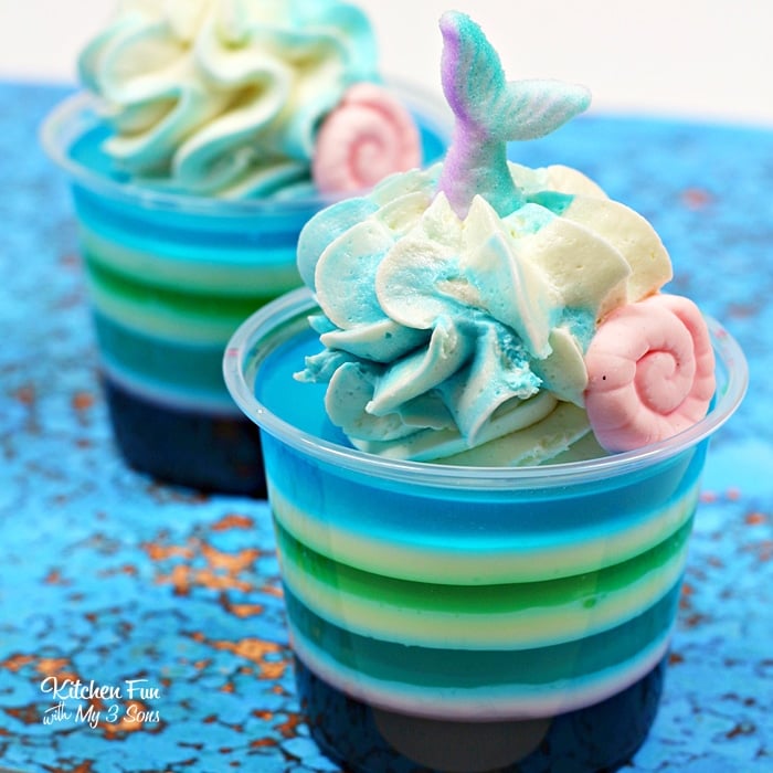 These Mermaid Jello Shots will be such a fun addition to your next party. Layered with colorful coconut rum jello and topped with a homemade whipped cream.