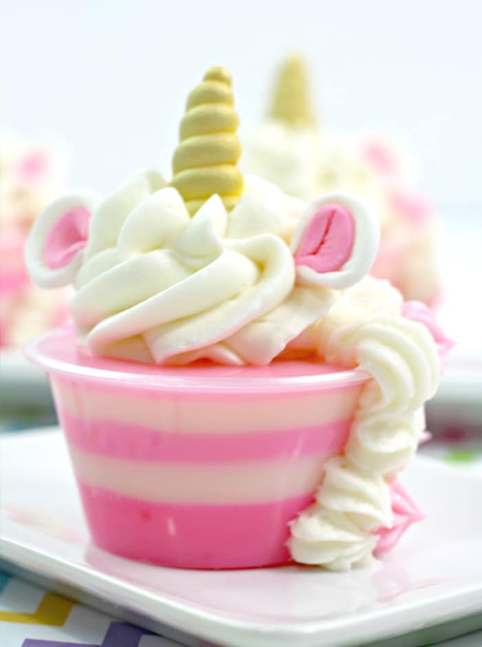 How fun are these Unicorn Jello Shots? Raspberry Jello with Bubble Gum Vodka and homemade whipping cream makes a pretty delicious treat for the grown-ups.
