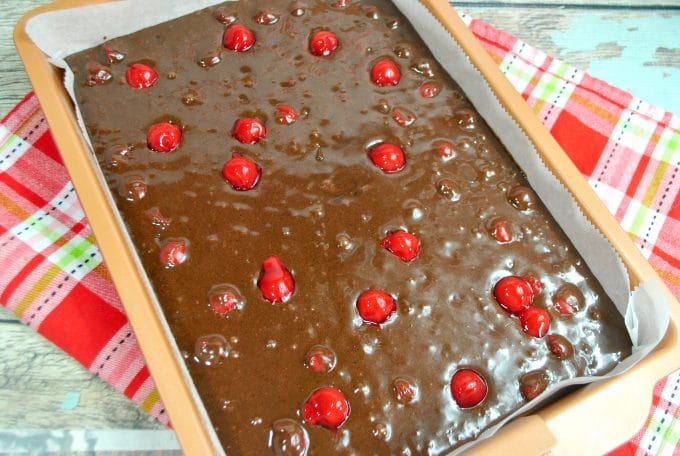 Chocolate brownie batter with cherries in a pan