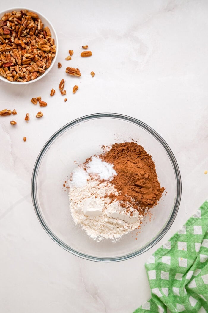 Chocolate cupcakes are filled with a sweet coconut pecan mixture and topped with chocolate buttercream in these German Chocolate Cupcakes. Dry cupcake ingredients in a bowl