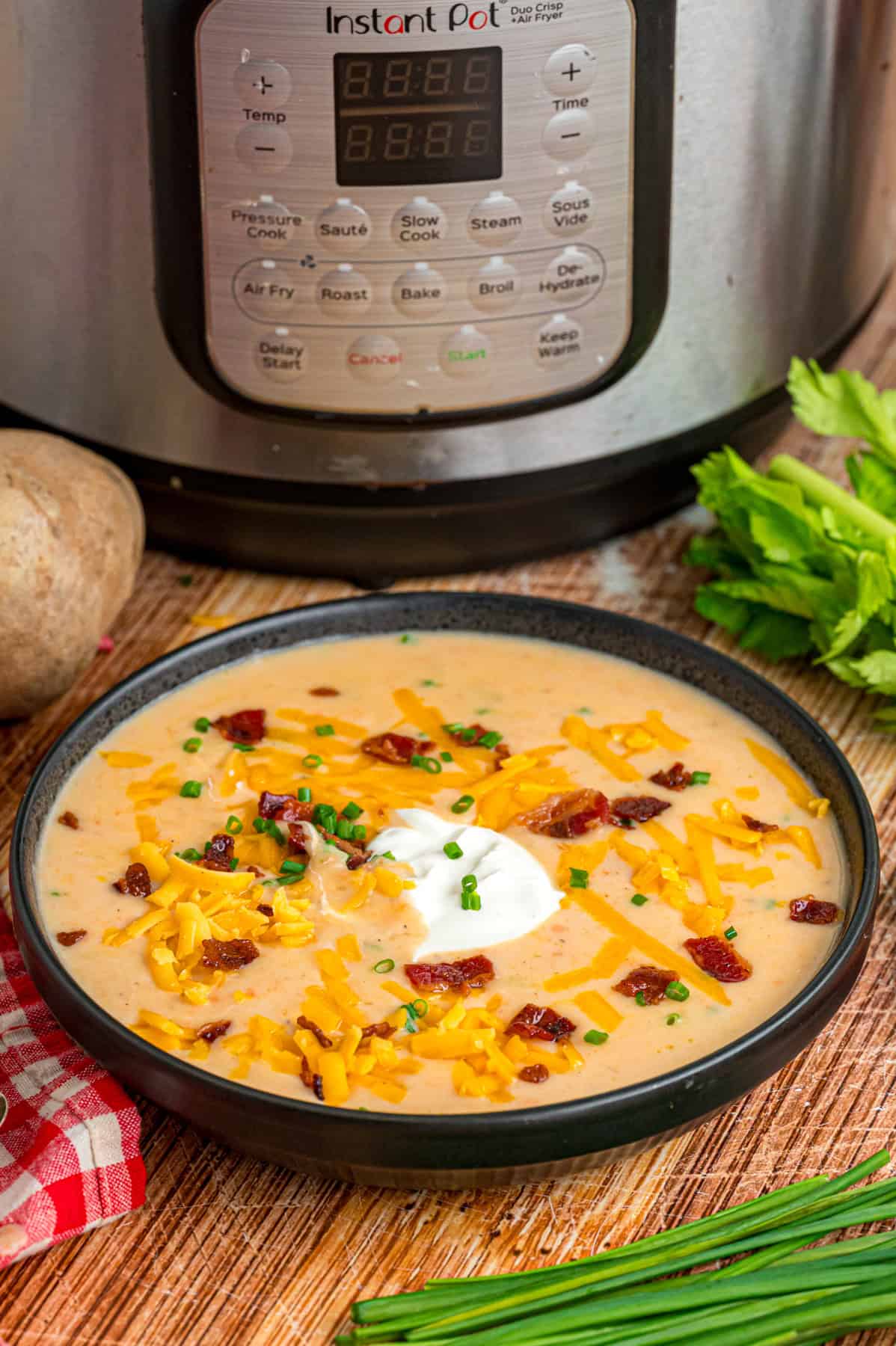 A bowl of potato soup in front of the Instant Pot
