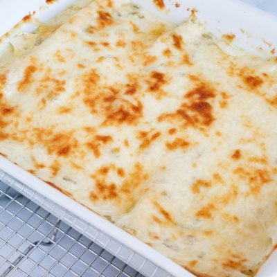 White Chicken Enchiladas casserole in a white baking dish.