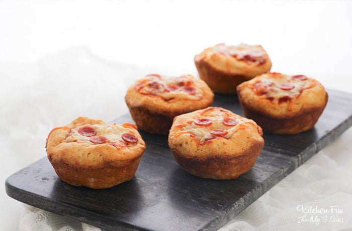 Five mini pepperoni pizzas on a small rectangular serving platter