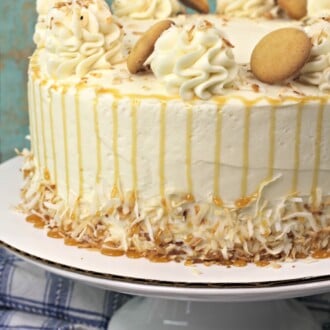 A banana layer cake topped with nilla wafers on a cake stand