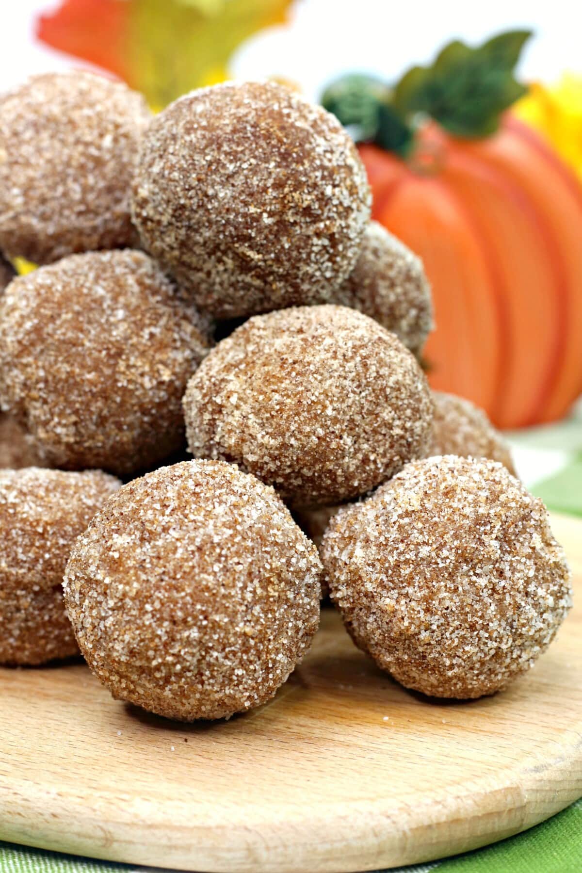 The pumpkin donut holes with a white and green tablecloth.