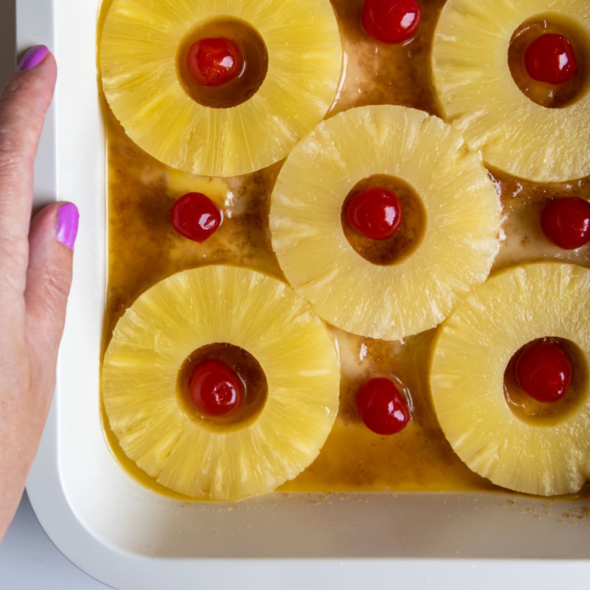 cake batter with pineapple and cherries on top
