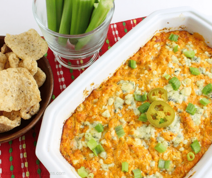 Baked easy buffalo chicken dip baked with pork rinds and celery beside dish