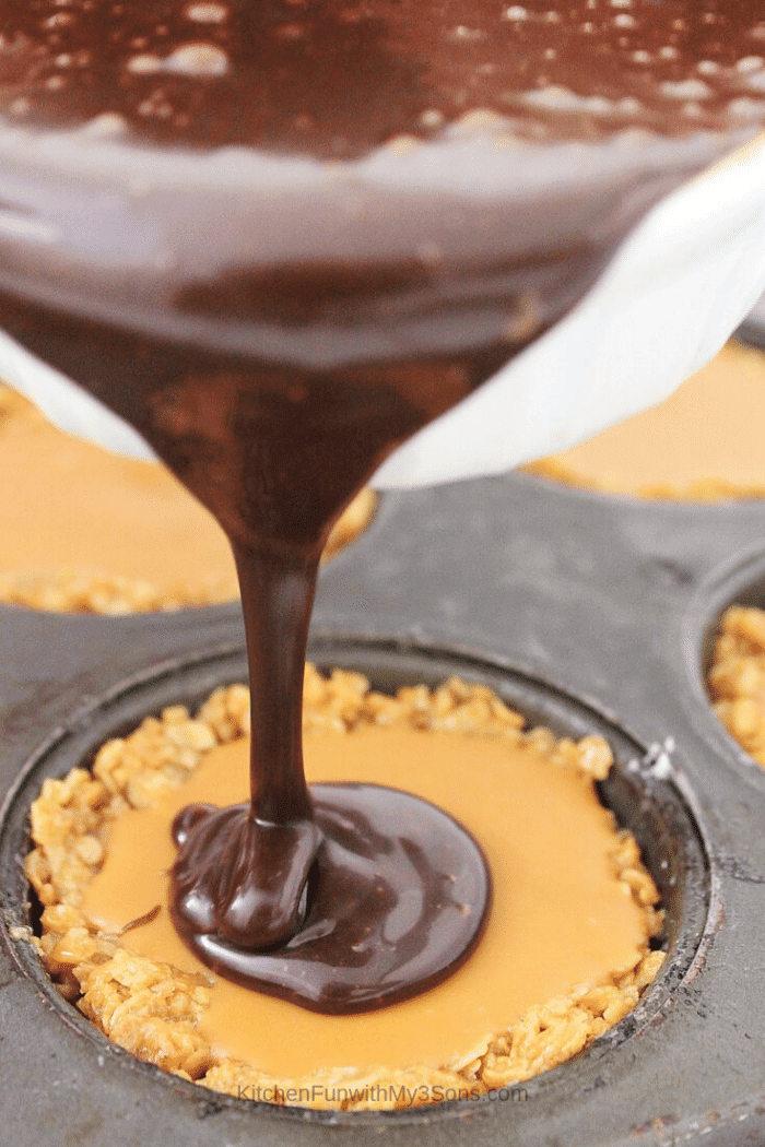 Pouring chocolate coating on top of peanut butter filled baked oatmeal cups