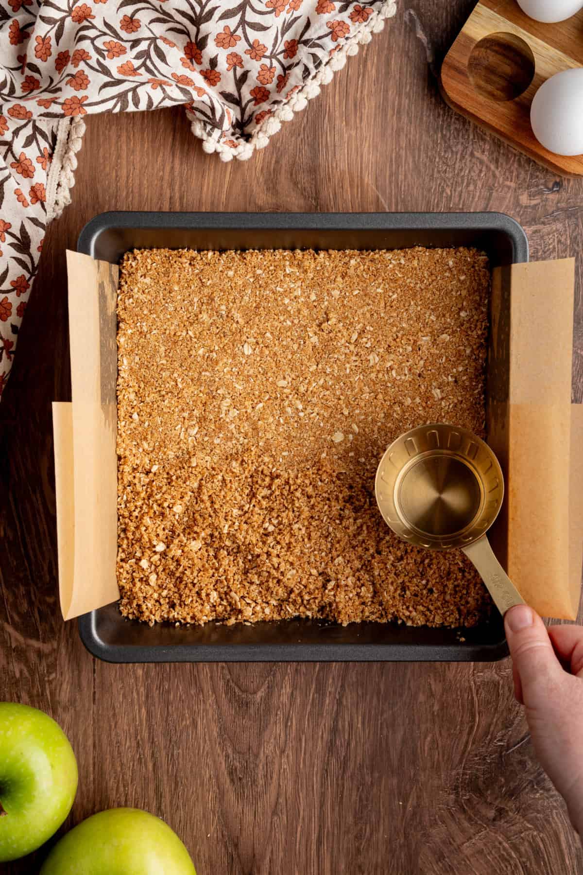 These Caramel Apple Cheesecake Bars combine creamy caramel cheesecake with cinnamon-spiced apples and a buttery oat crumble. pressing crushed graham crackers into a pan to make a crust.