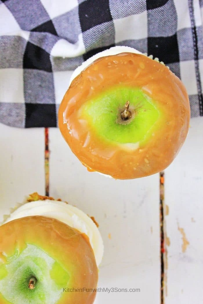 An overhead picture of the top of caramel apple cupcakes topped with apple slices