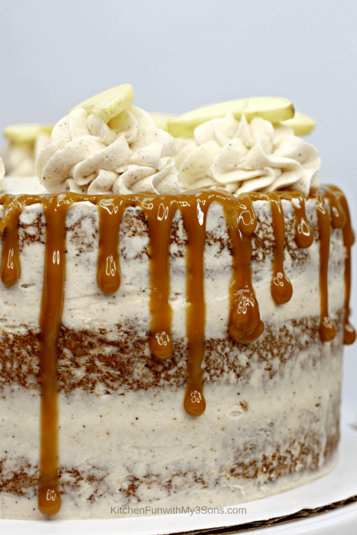 An up close picture of an apple spice cake with frosting and caramel drizzle